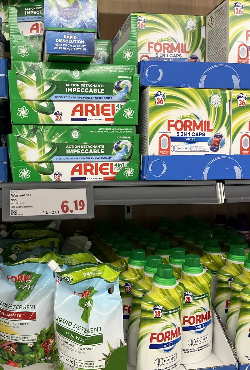 Lidl-schap met dozen Formil 5-in-1 caps White van 36 wasbeurten, daaronder Formil Nature navulzakken en Formil White vloeibaar